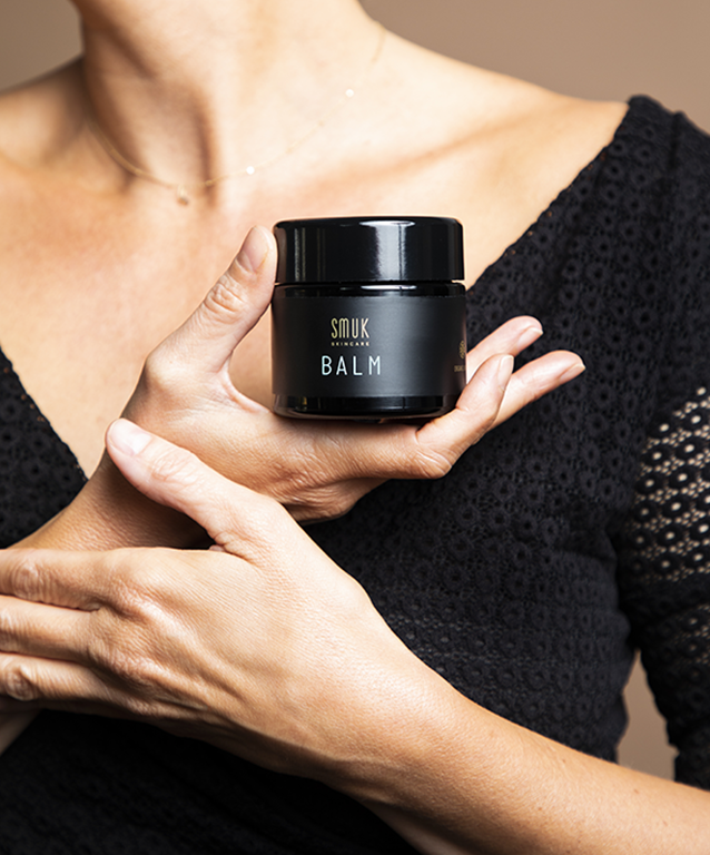 Kvinde holder dåse med økologisk hudpleje balm fra SMUK skincare