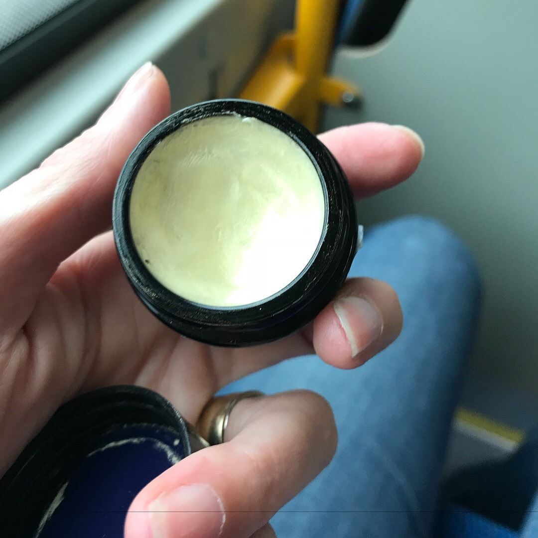 Hånd holder sort dåse med SMUK skincare golden moments lip balm