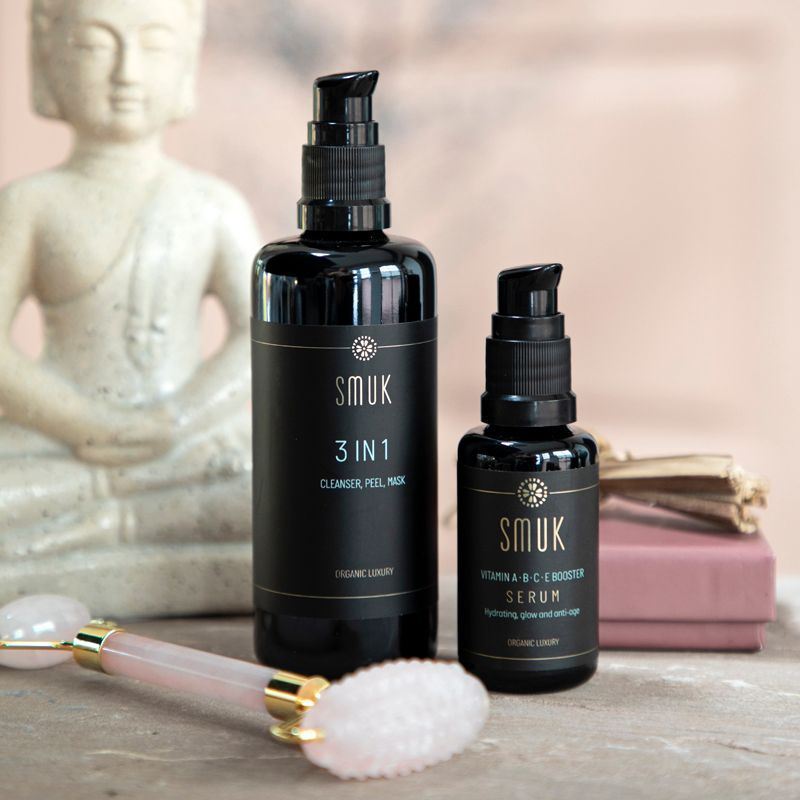 2 sorte flasker med SMUK skincare prisvinnende økologisk 3 in 1 cleanser peel mask og vitamin serum og rosakvartsrulle beauty tool