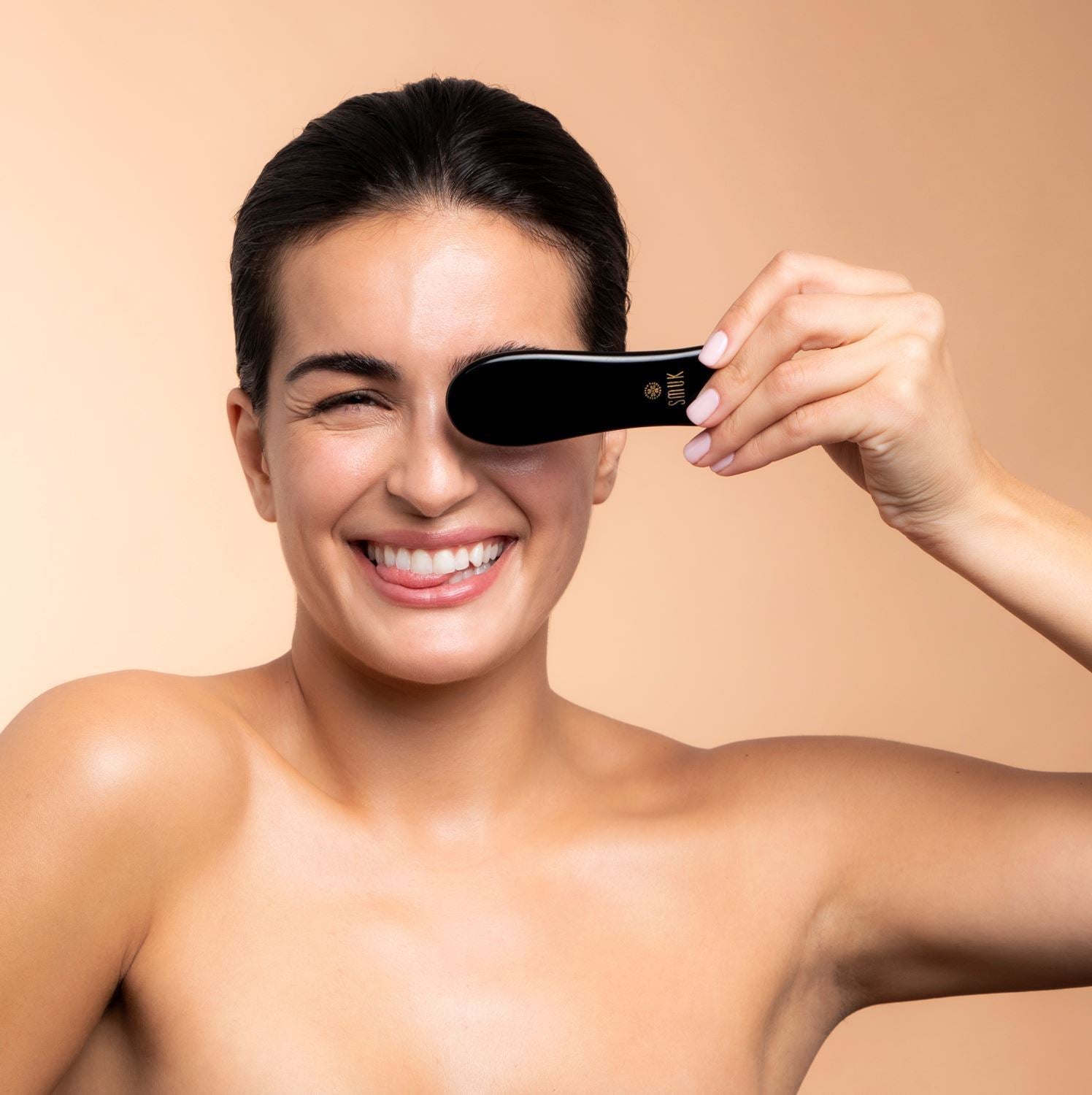 Kvinde bruger obsidian Gua Sha beauty tool