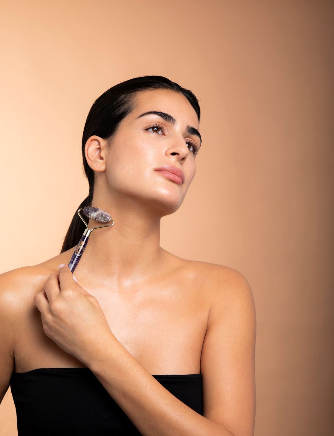 Kvinde bruger ametystrulle beauty tool