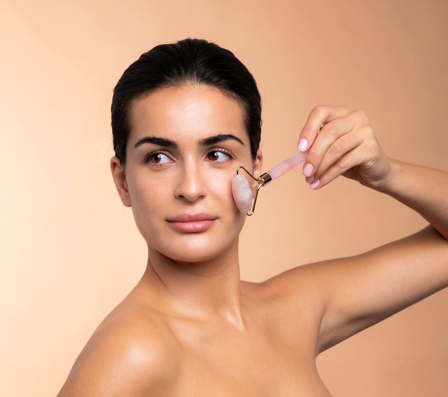 Kvinde bruger rosakvartsrulle beauty tool