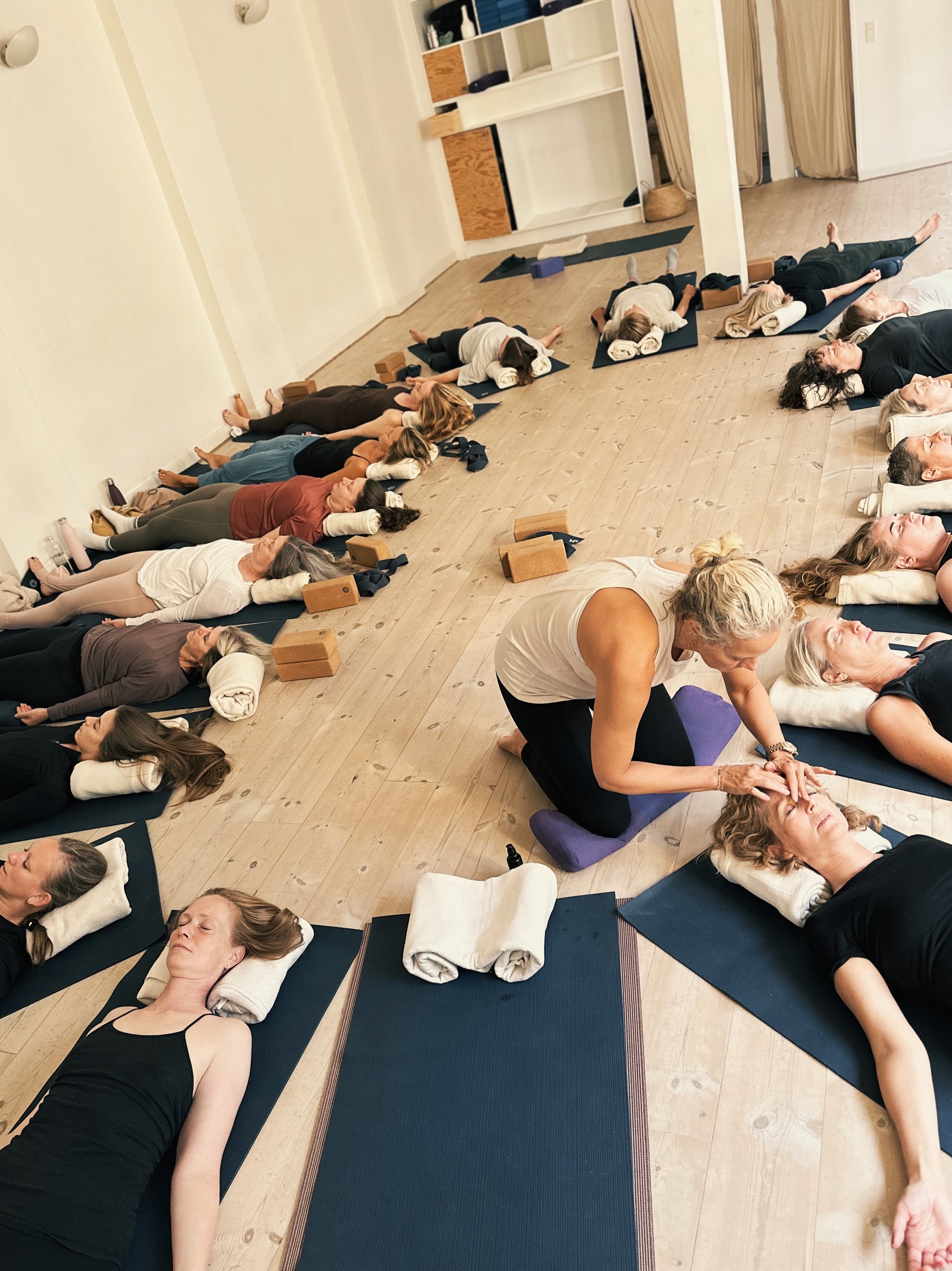 Kvinder på yogagulvet får ansigtsmassage