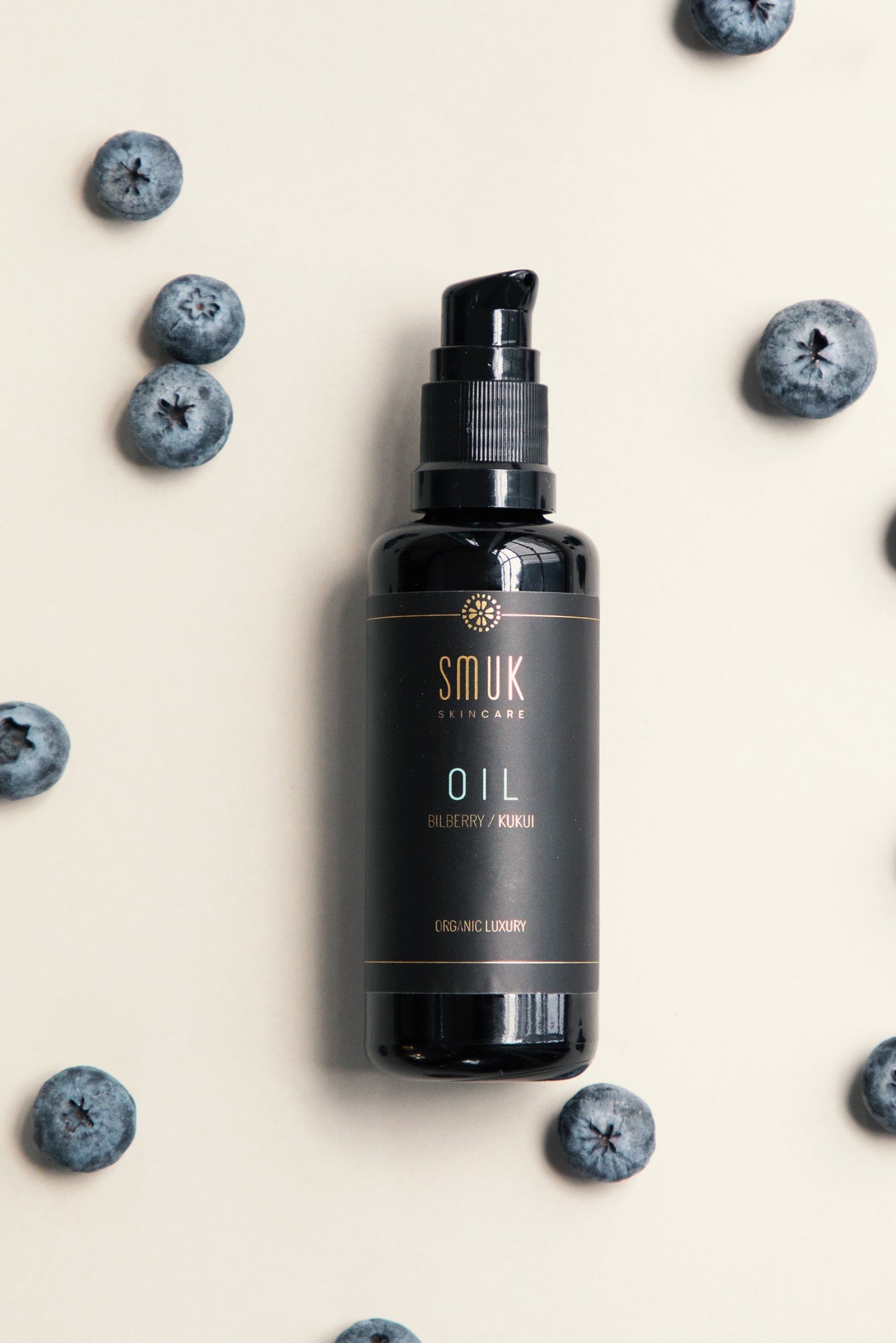 Sort flaske med SMUK skincare facial oil og blåbær