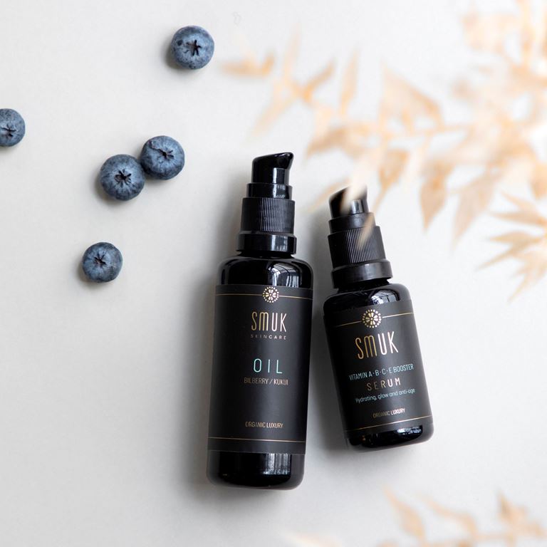 Smuk Skincare olie og serum med naturlige ingredienser vist sammen med blåbær