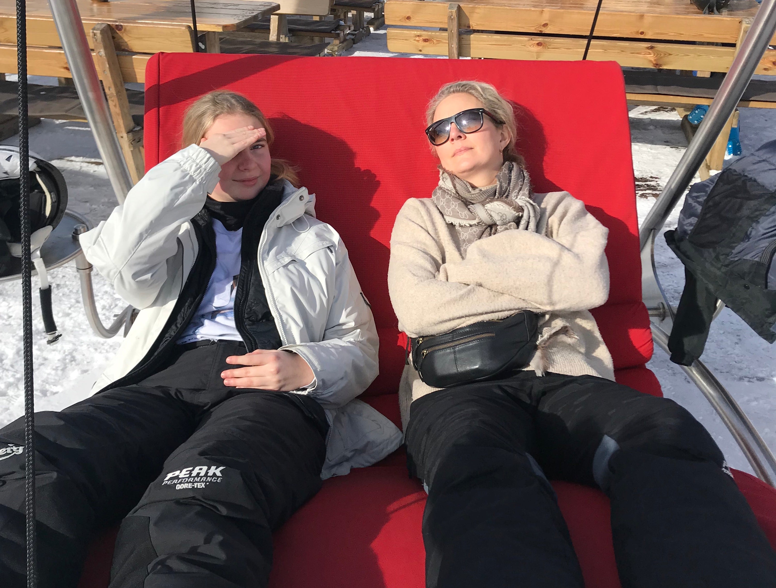 Afslapning i solsengen på skiferie med vintersol og sne omkring