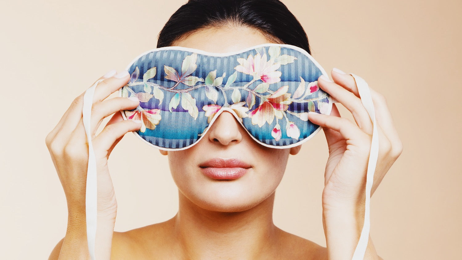 Kvinde holder en beauty sleep mask med blomsterdekoration lavet af silke